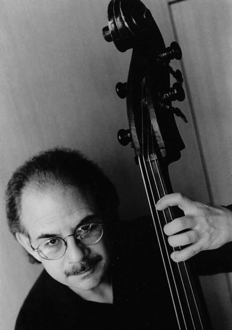 A man holding a double bass in front of him.