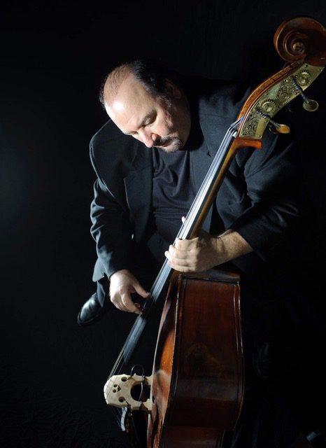 A man holding a double bass in his hands.