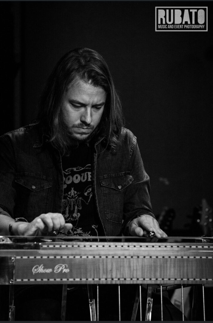 A man in black shirt playing an electronic instrument.