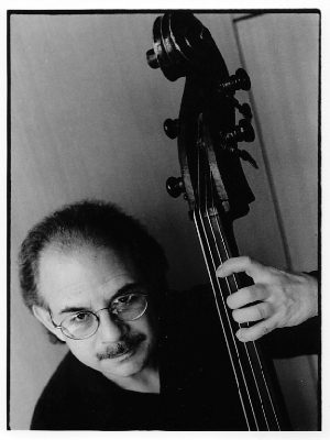 A man holding a double bass in front of him.