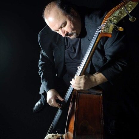 A man holding a double bass in his hands.