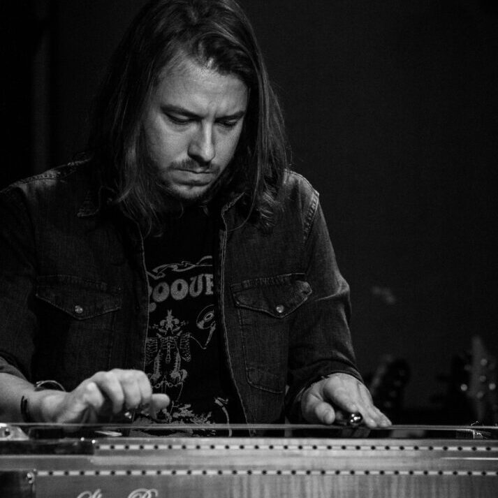 A man in black shirt playing an electronic instrument.