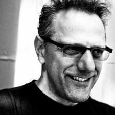 A man with glasses smiling for the camera.